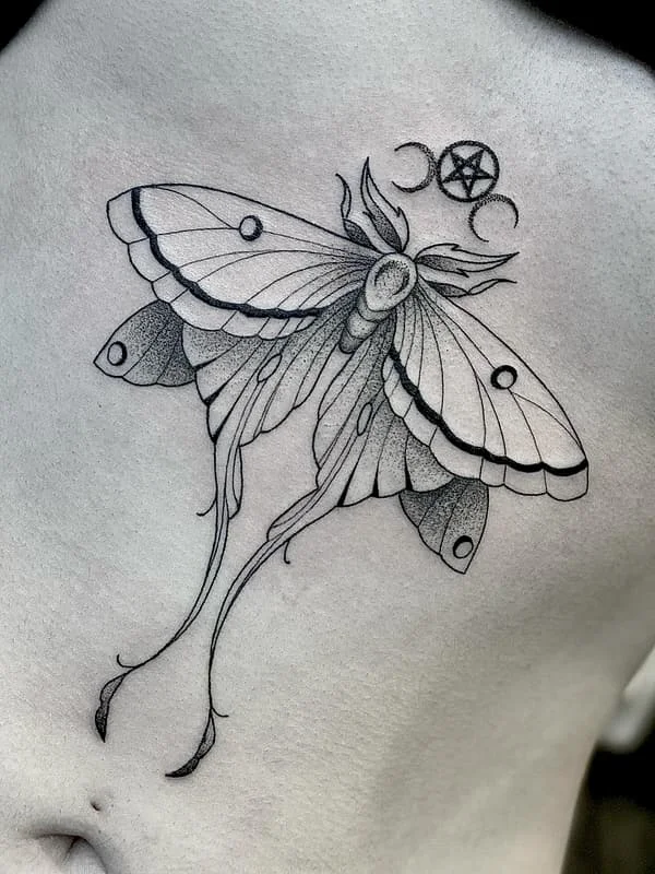 Detailed blackwork moth tattoo with celestial elements.