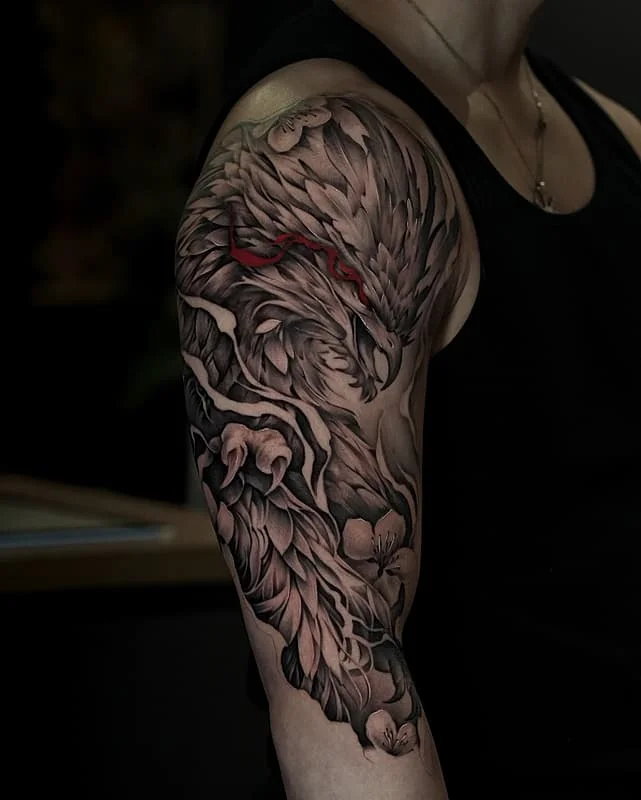 Detailed black-and-grey eagle tattoo on arm.