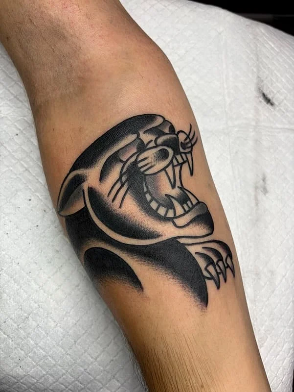 Black and grey roaring lion tattoo on calf.