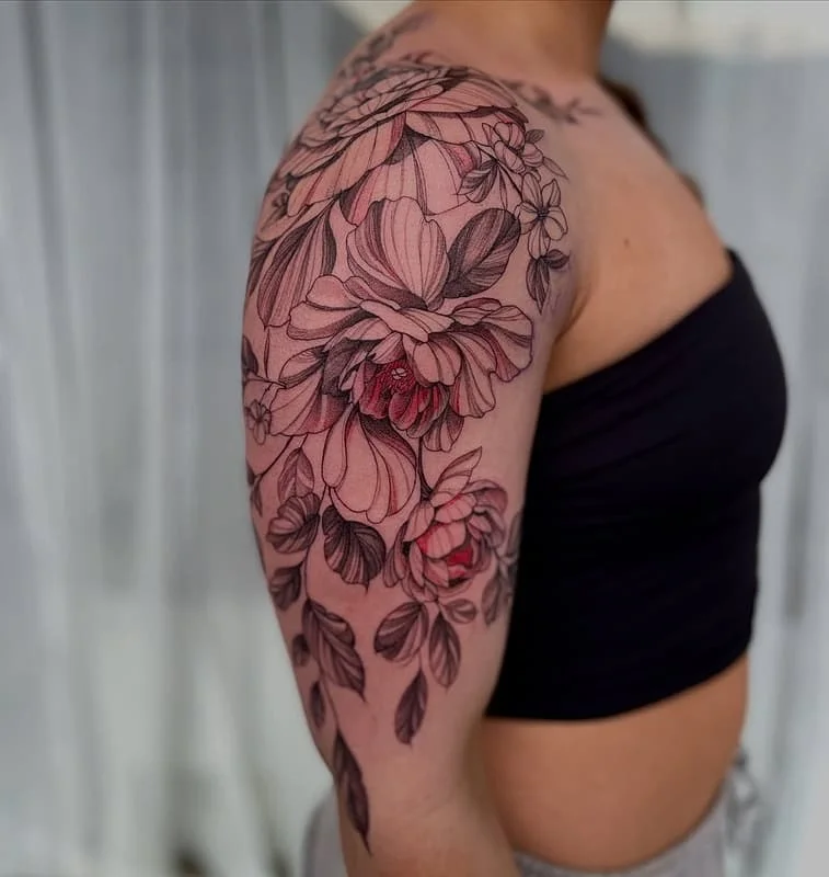 Large floral tattoo on a woman's arm and shoulder.