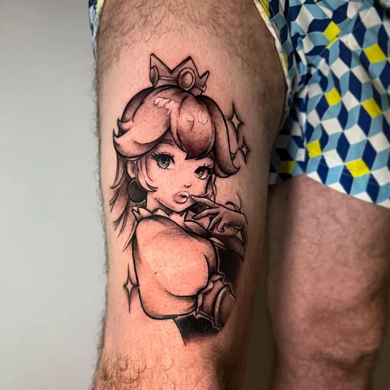Illustrative black-and-grey tattoo of a character on thigh.