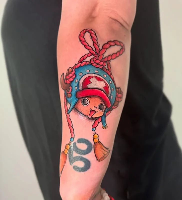 Colorful cartoon character tattoo on forearm.