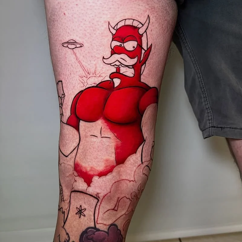 Colorful cartoon devil tattoo on thigh.