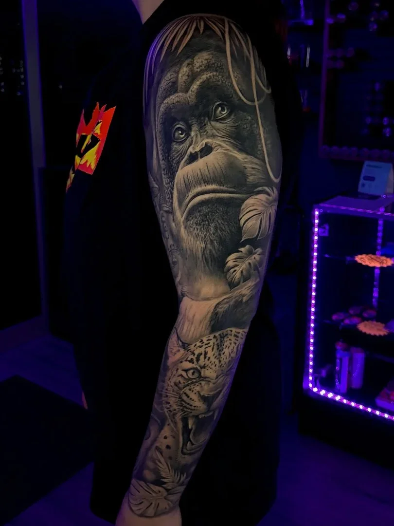 Detailed black and grey realism full sleeve featuring a gorilla and leopard