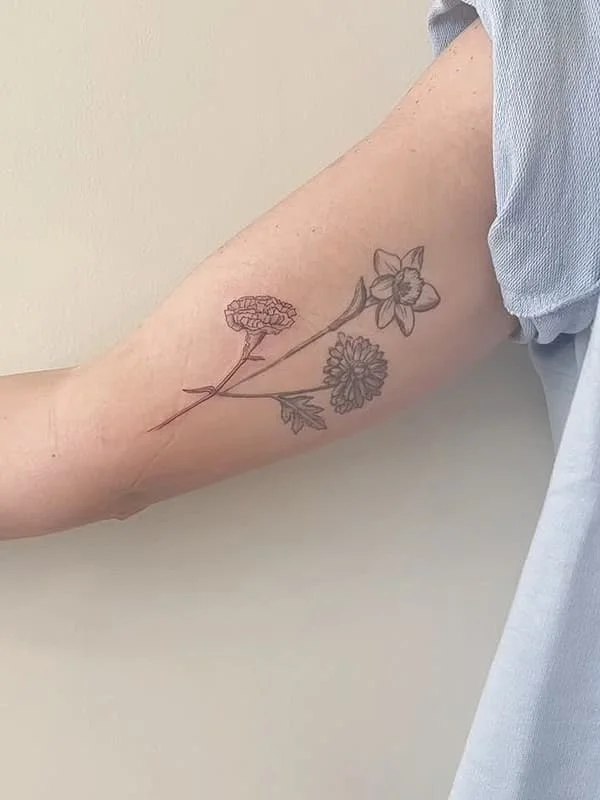 Fine-line floral tattoo on the arm.