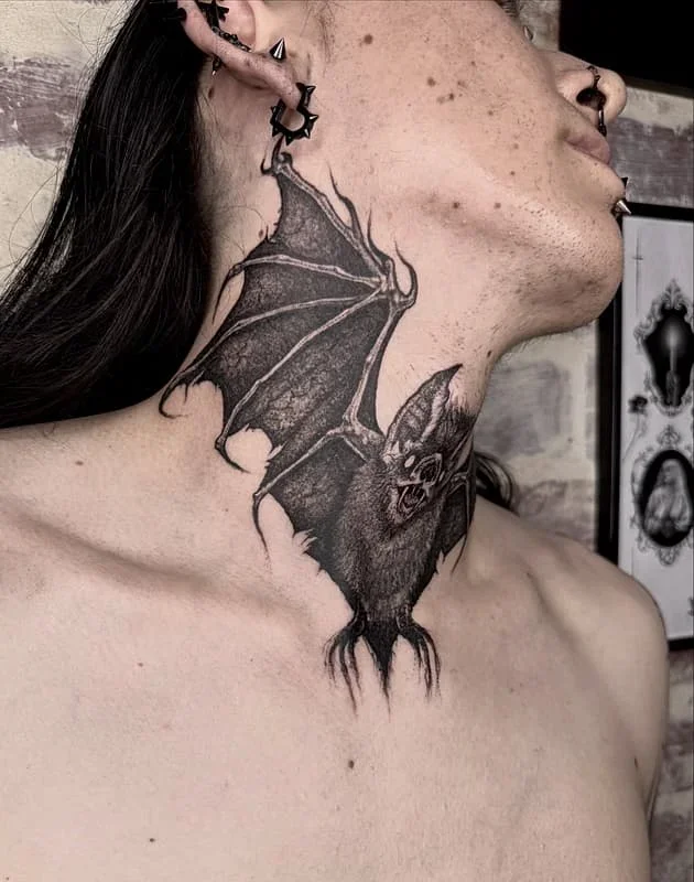 Realistic black-and-grey bat tattoo on neck.