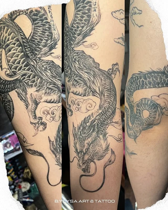 Large black-and-grey dragon tattoo on arm.