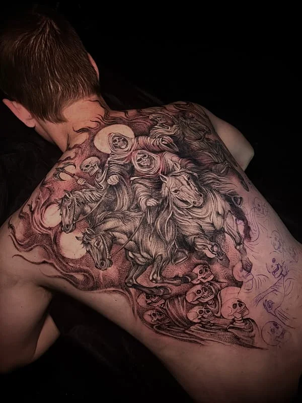 Large black-and-grey tattoo of horsemen and skulls on back.
