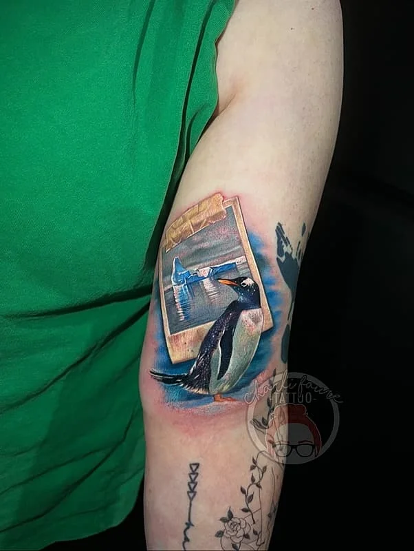 Realistic penguin tattoo on arm in a clean studio setting