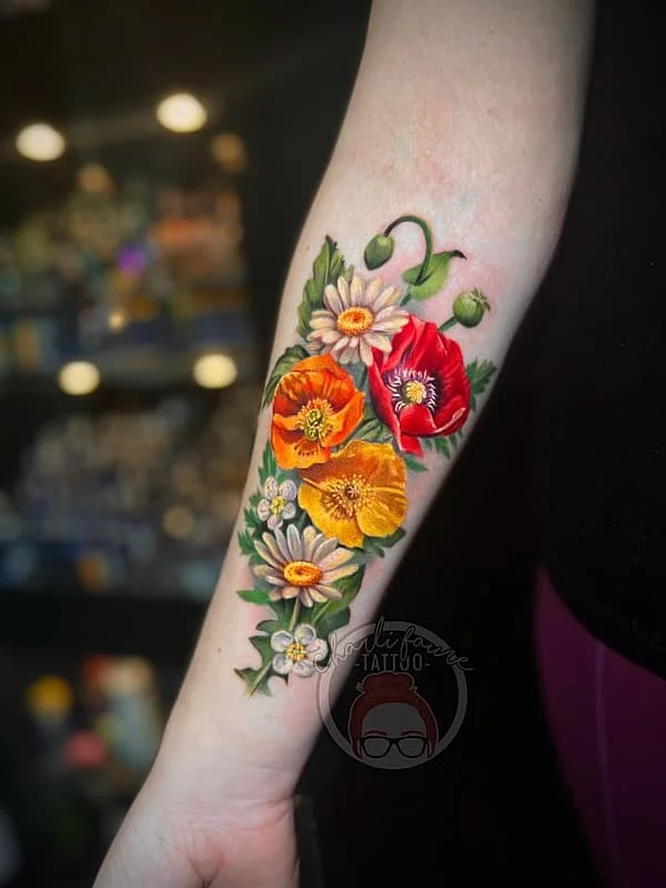 Vibrant watercolor floral tattoo on forearm