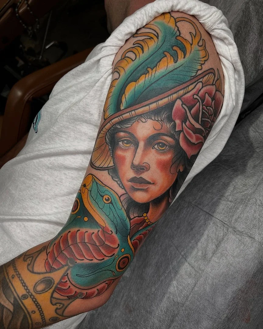 Vibrant full-sleeve tattoo of a woman's face with a feather.