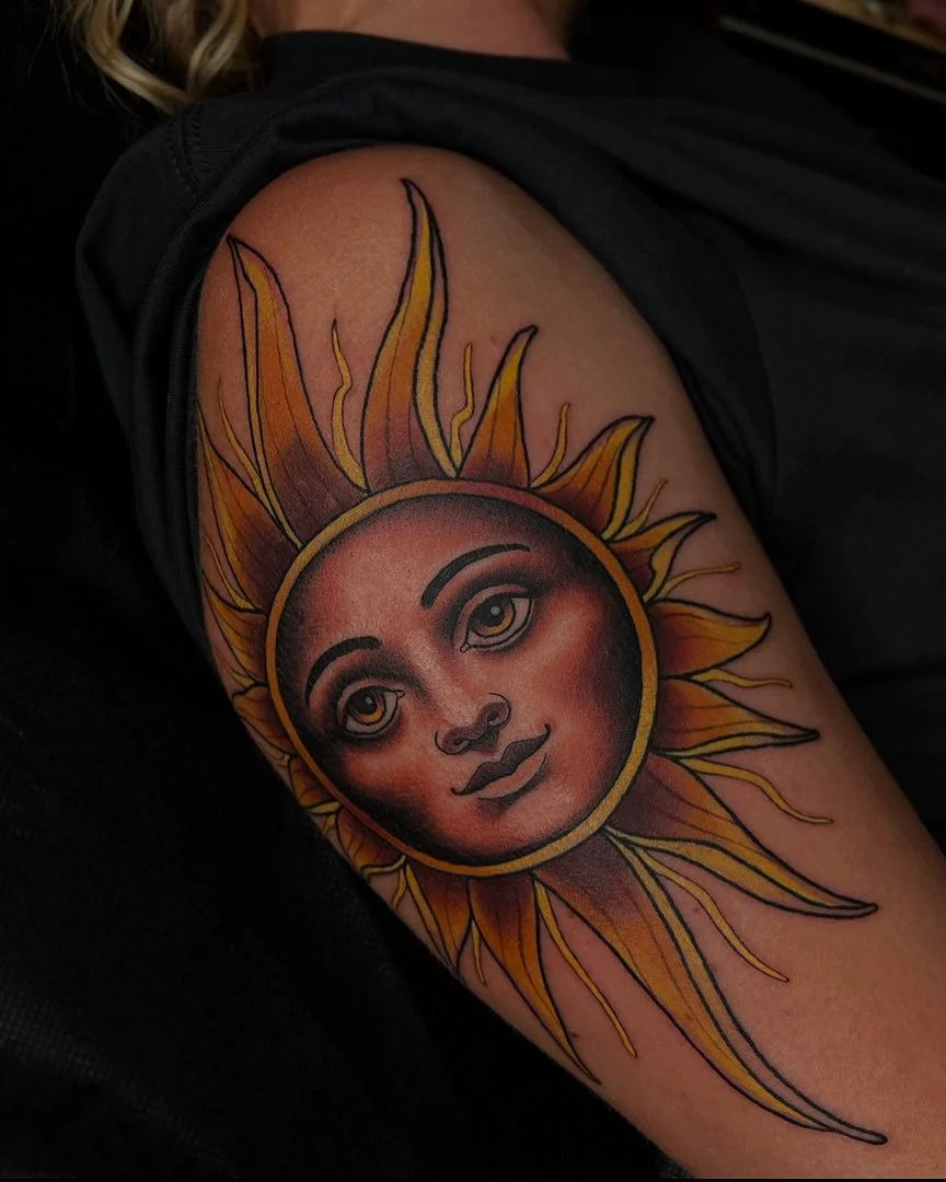 Colorful sun tattoo with a smiling face on the arm.