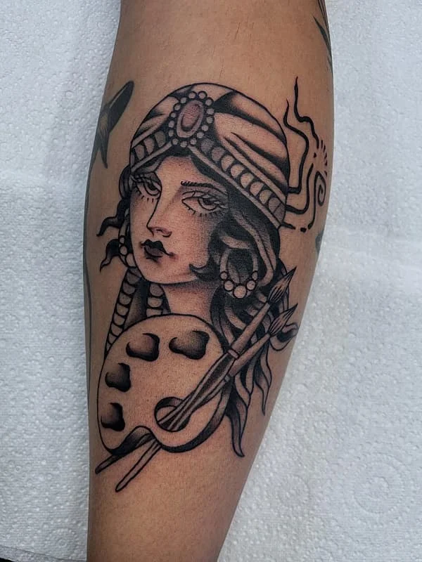 Illustrative blackwork tattoo of a female portrait on forearm.
