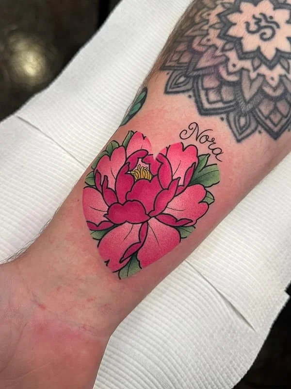 Colorful flower heart tattoo with the name Nora.