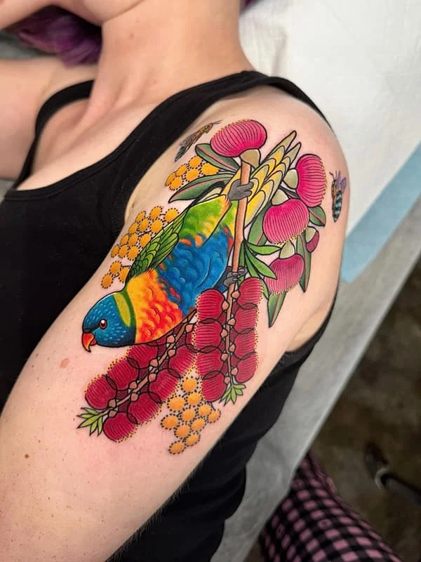 Colorful parrot and flowers tattoo on shoulder and arm.