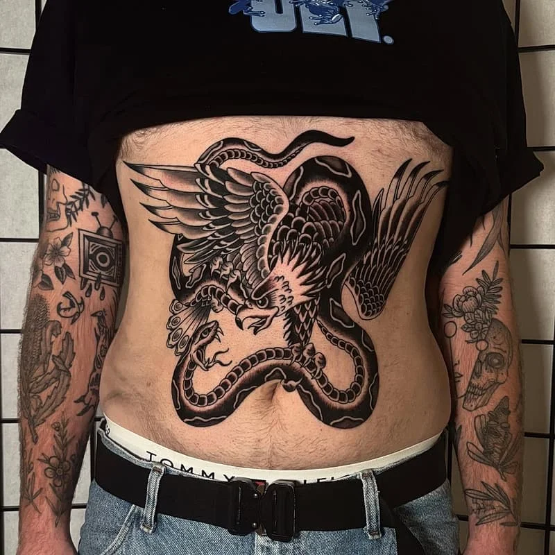 Large blackwork tattoo of a dragon and eagle on chest.