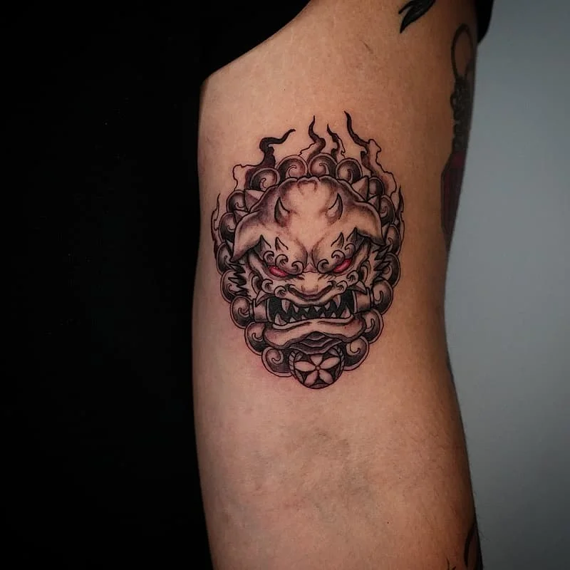 Japanese lion tattoo on the arm with clouds.
