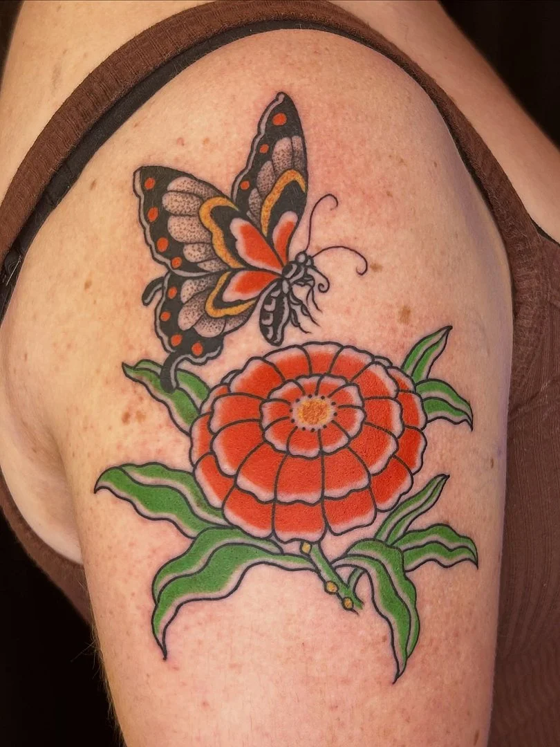 Colorful butterfly and flower tattoo on shoulder.