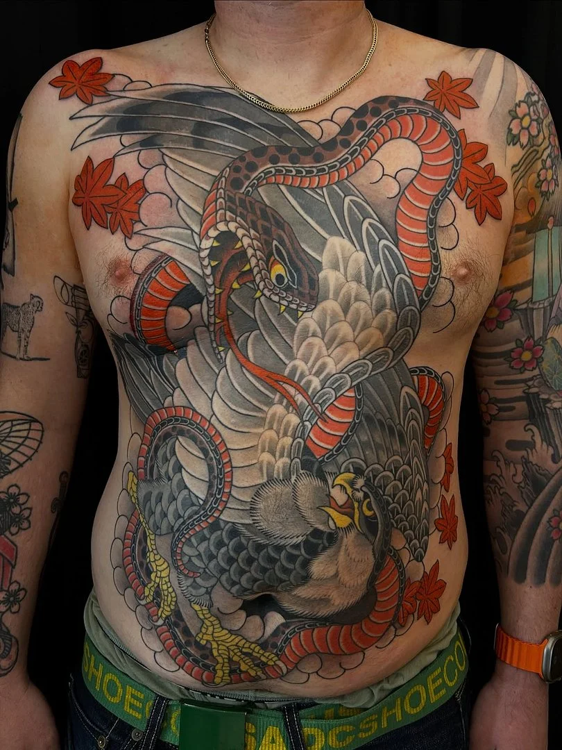 Large Japanese tattoo featuring a dragon and snake on chest.