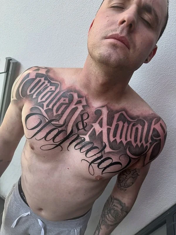 Bold script tattoo on a man's chest.