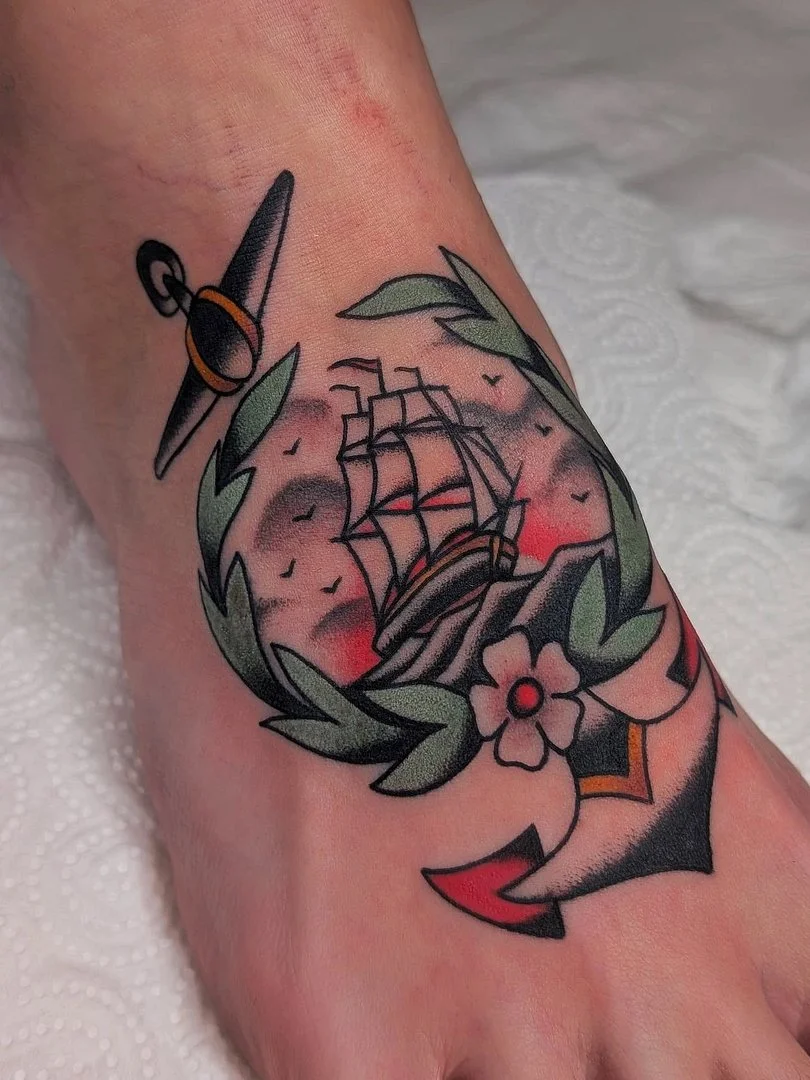 Traditional tattoo of a ship and anchor on ankle.
