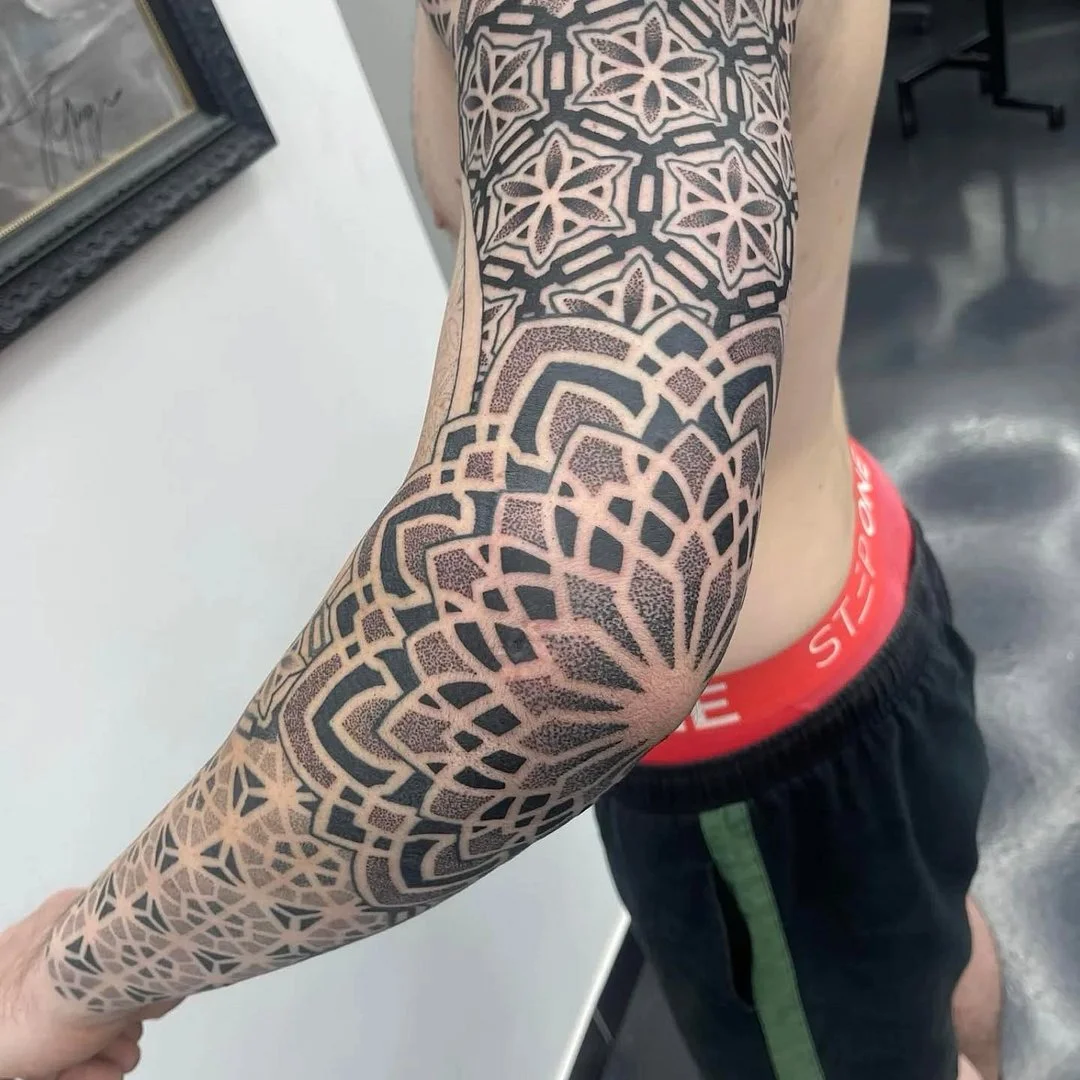 Large geometric blackwork half sleeve on arm and forearm