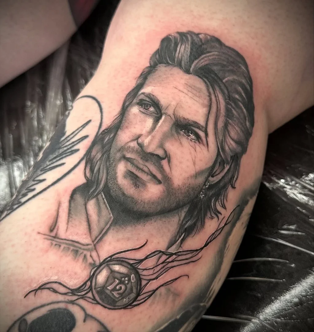 Detailed black-and-grey portrait tattoo on arm.