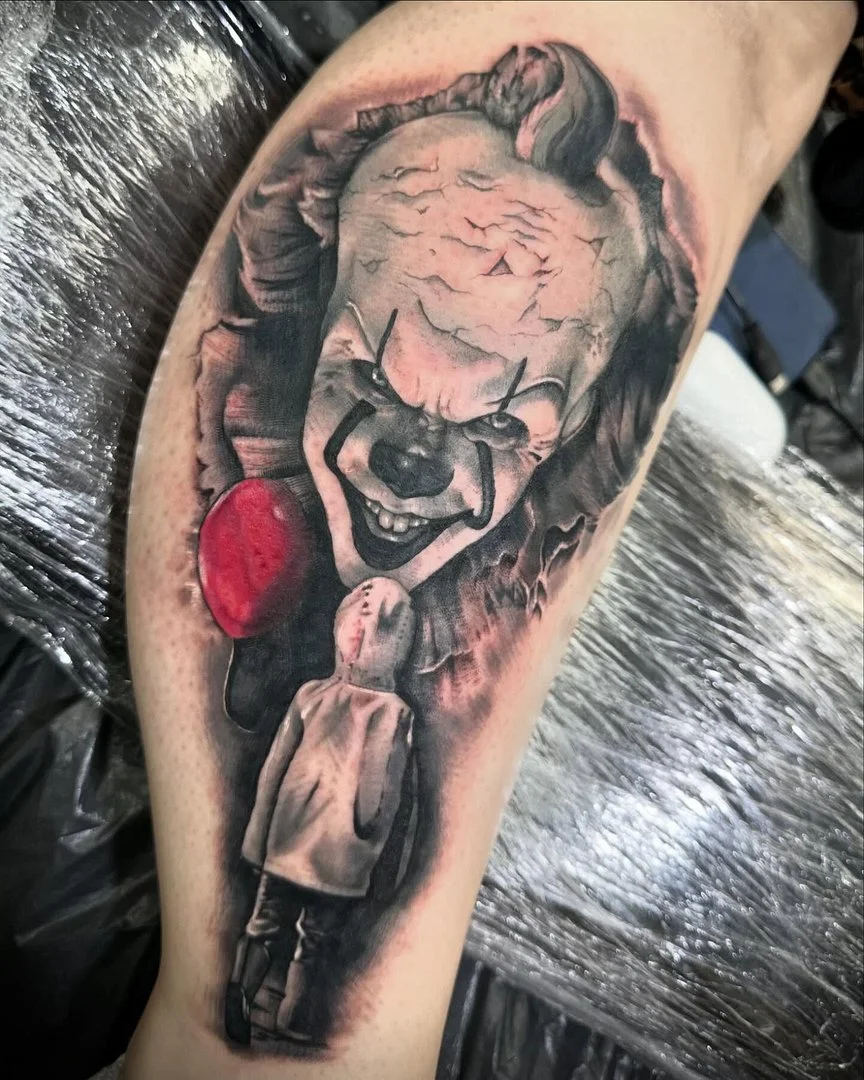 Realistic black-and-grey clown tattoo on arm.