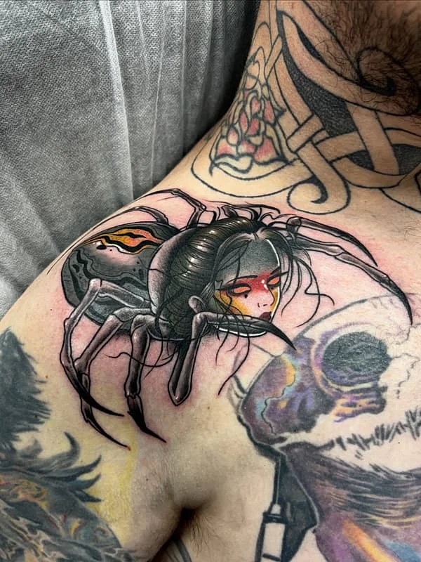 Illustrative spider tattoo on shoulder with female figure.