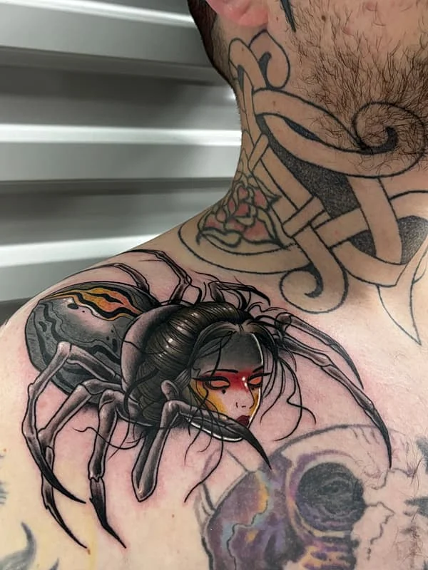 Illustrative spider tattoo on shoulder and neck.