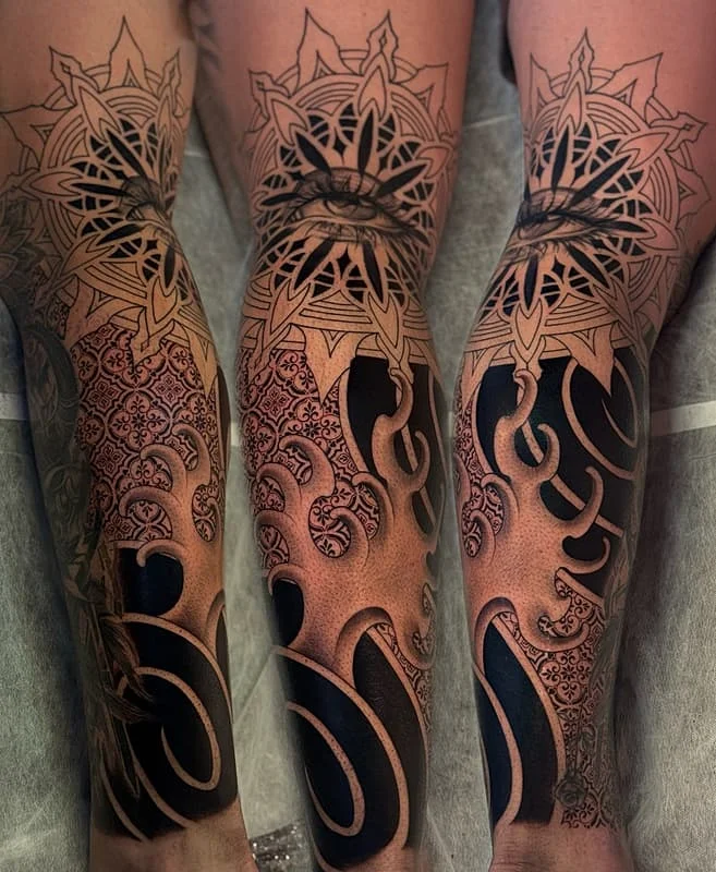 Intricate blackwork geometric tattoo on forearm and full sleeve.