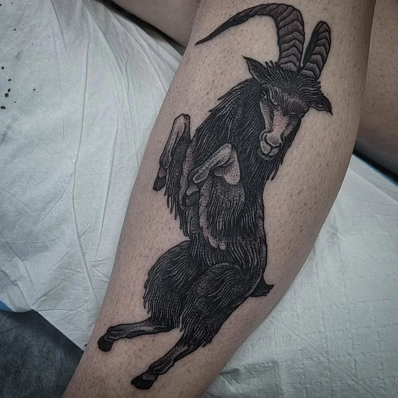 Detailed blackwork tattoo of a goat on a leg.