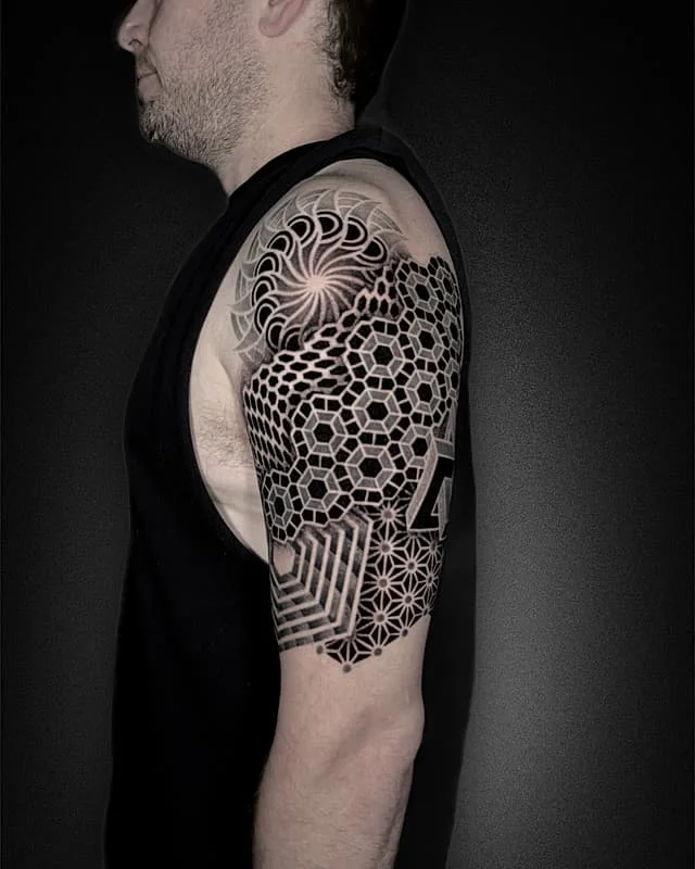 Large geometric blackwork tattoo on a man's arm.