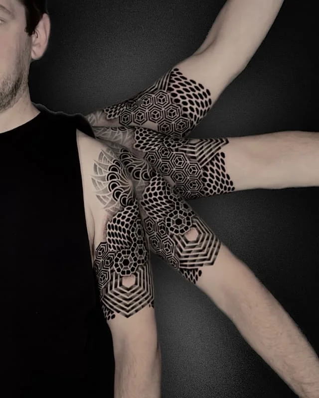 Intricate geometric blackwork tattoo on arm.