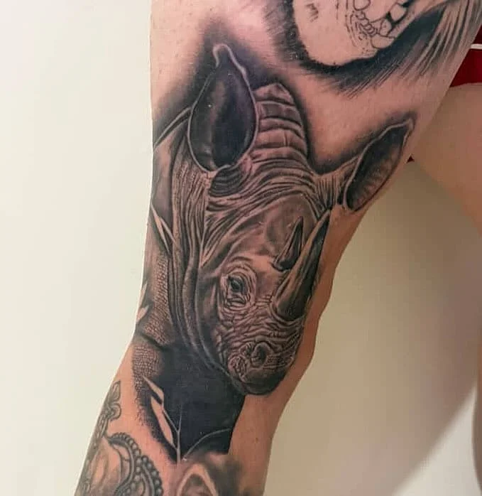 Realistic black and grey rhino tattoo on arm