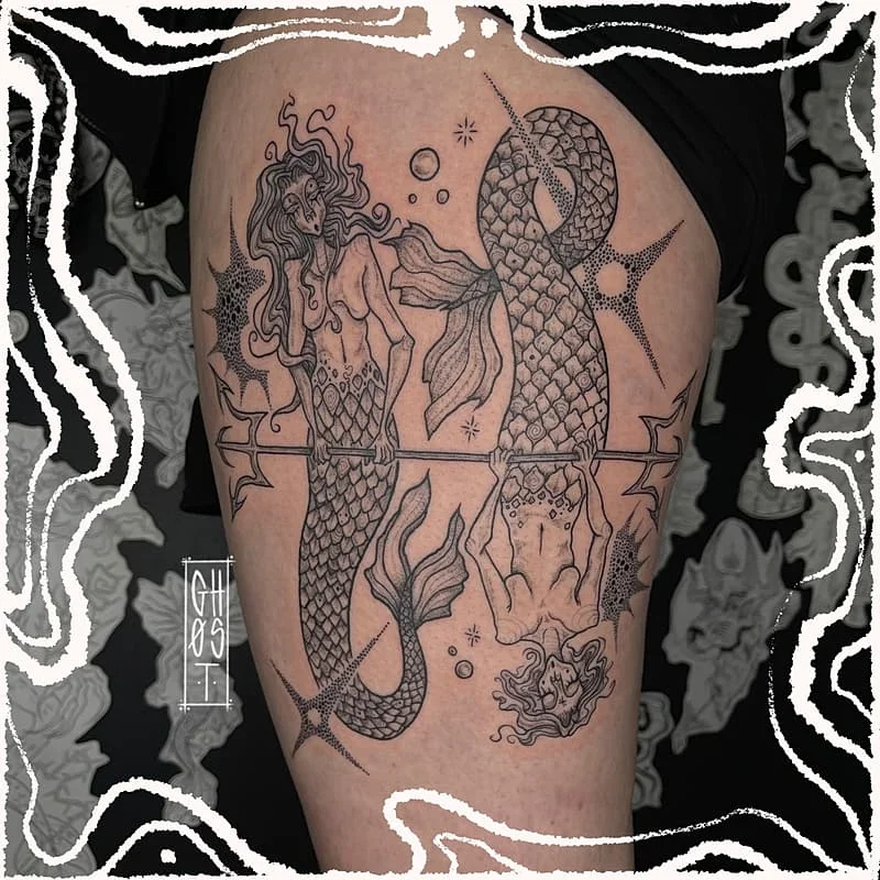 Illustrative blackwork mermaid tattoo on thigh.
