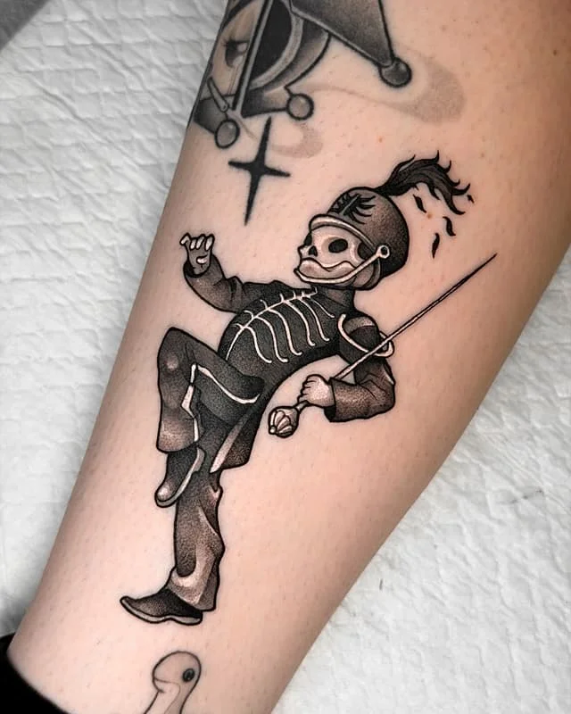 Black and grey skeleton tattoo on forearm.