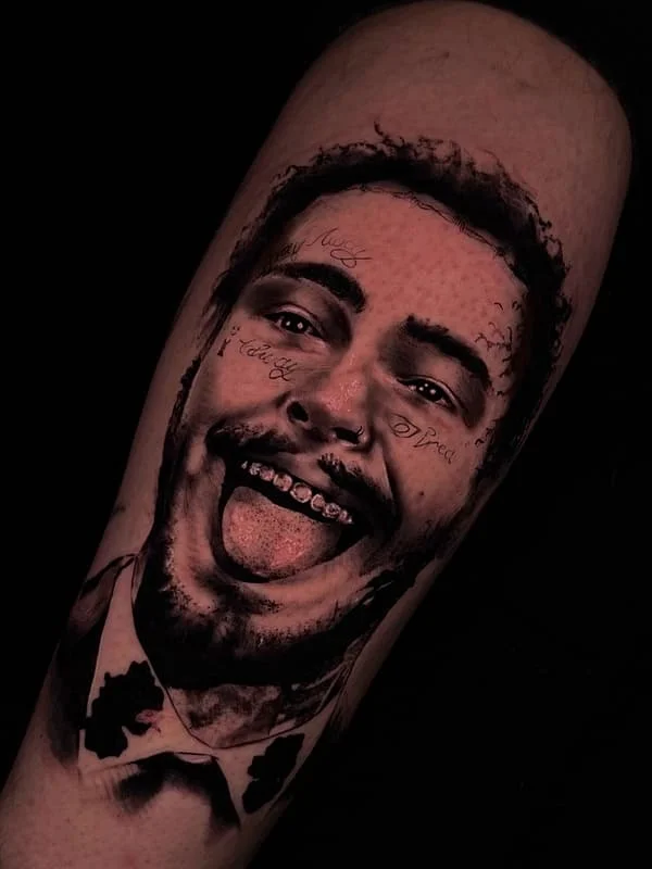 Large black-and-grey portrait tattoo on leg.