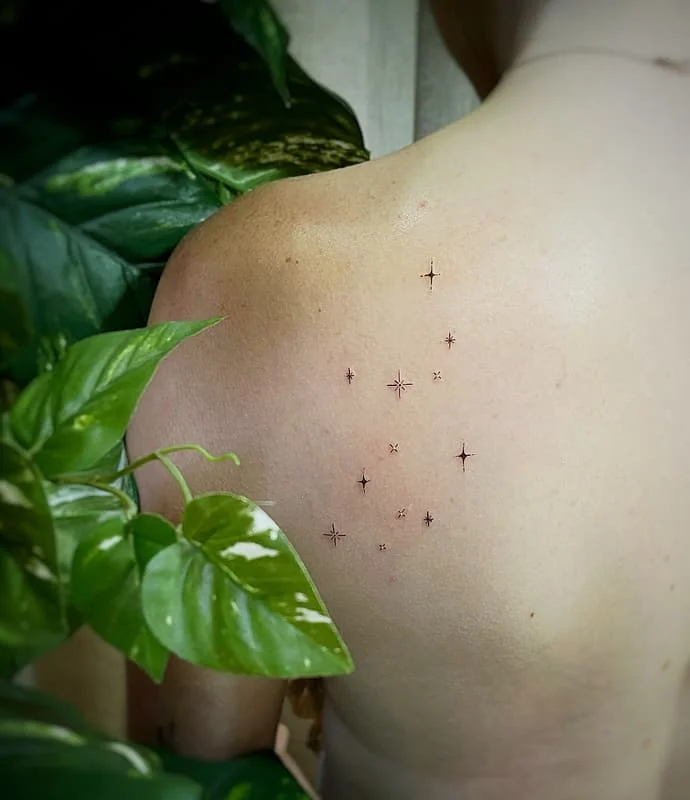 Minimalist star tattoo on a person's back.