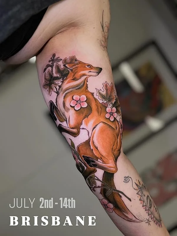 Colorful fox tattoo with flowers on the arm.