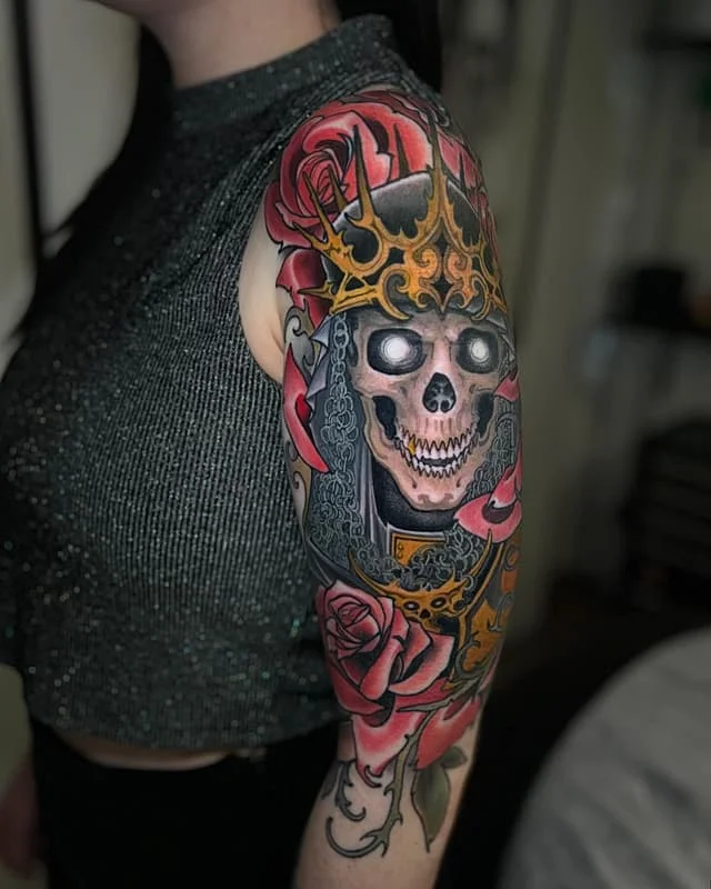 Colorful skull and roses full-sleeve tattoo on arm.