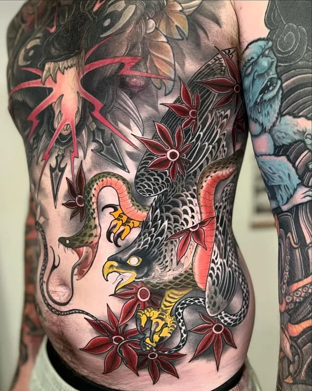 Large traditional tattoo of an eagle and snakes on the chest.