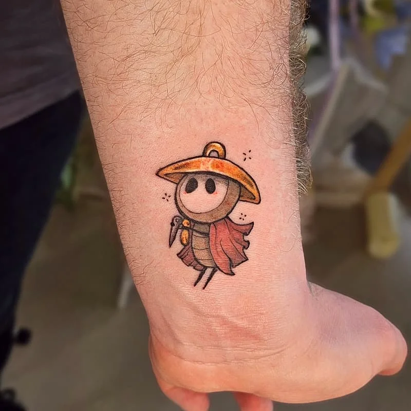 Colorful cartoon character tattoo on forearm.