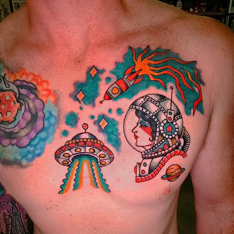 Colorful chest tattoo featuring an astronaut and rocket.