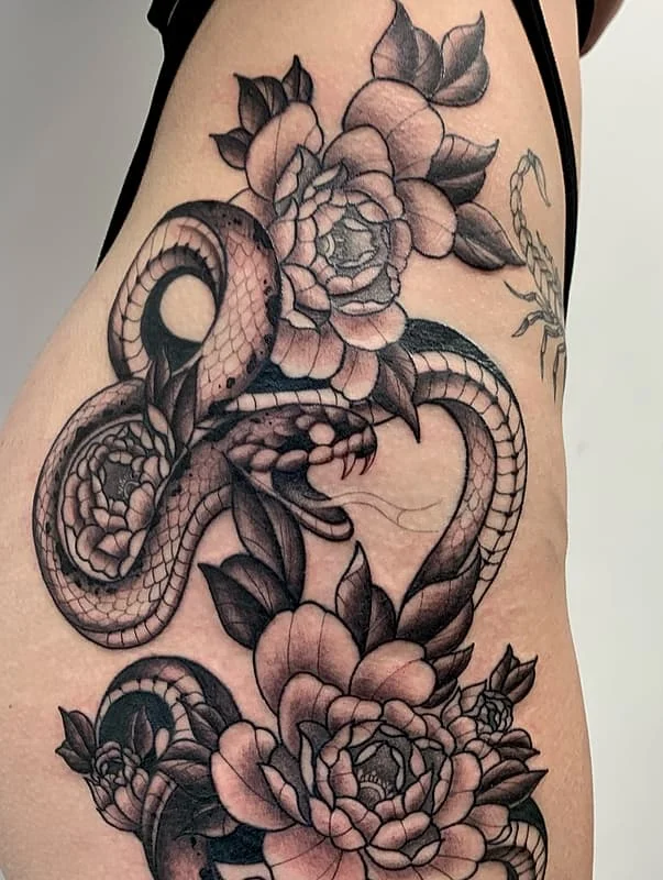 Black-and-grey snake and flower tattoo on rib.