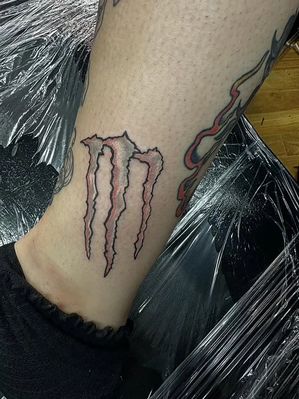 Illustrative claw marks tattoo on ankle.