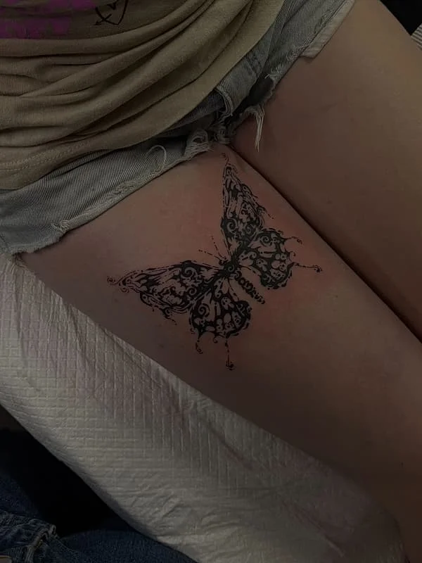 Illustrative butterfly tattoo on a thigh.