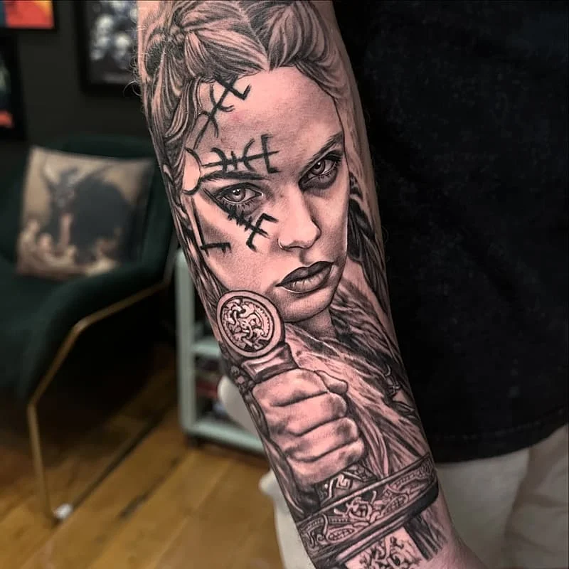 Black-and-grey realism tattoo of a fierce warrior on forearm.