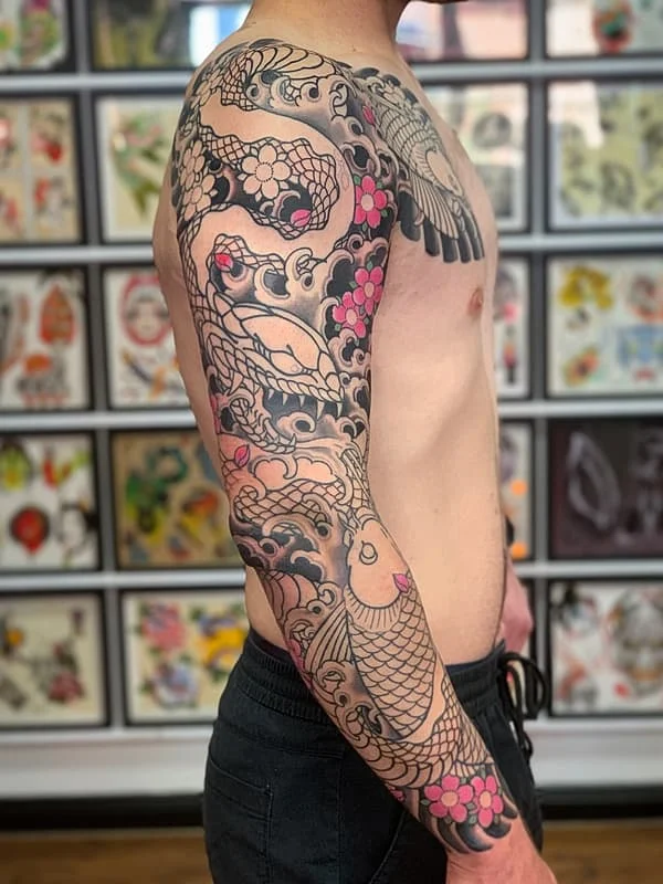 Japanese full-sleeve tattoo featuring koi fish and dragon.