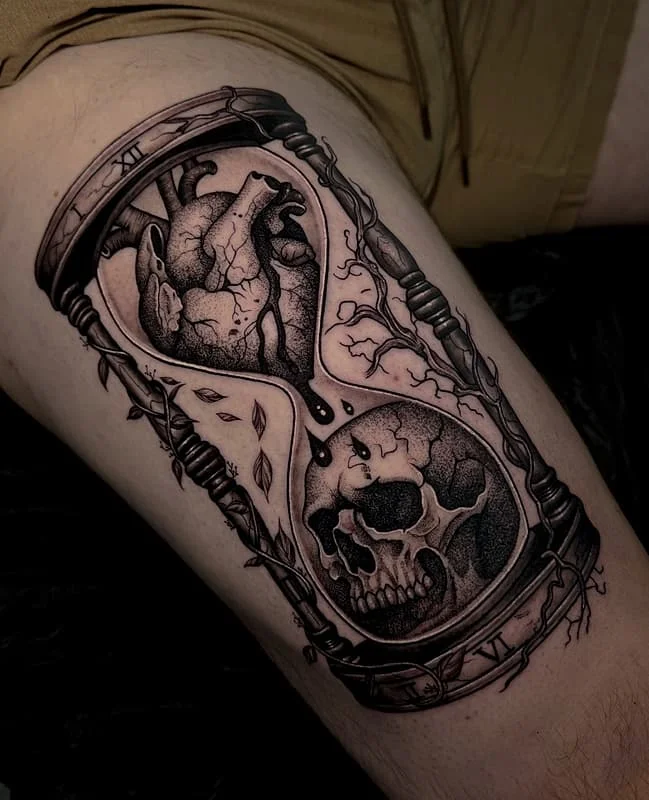 Black-and-grey hourglass tattoo with skull and heart.
